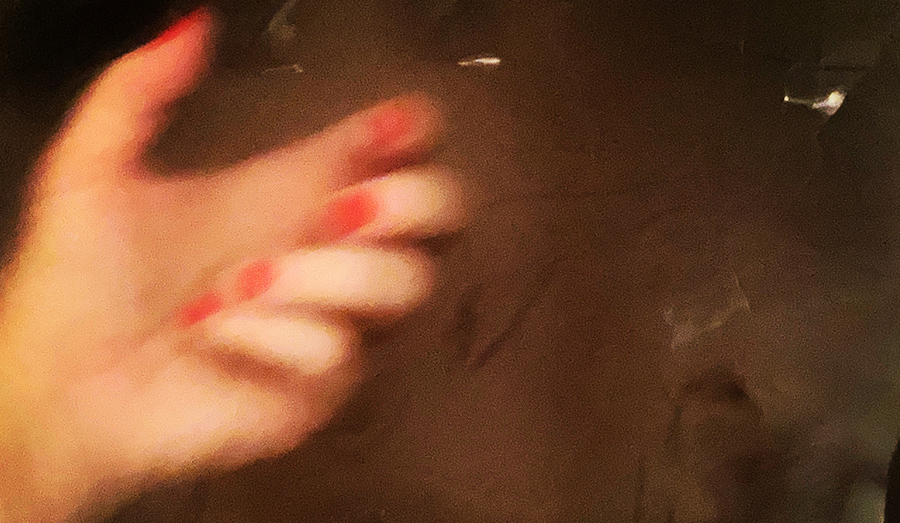 A blurry hand against a dark backdrop